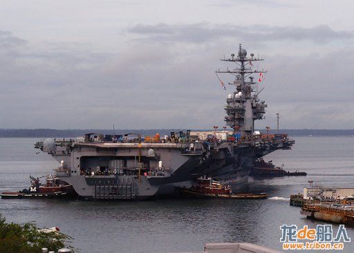 Tug boats assist the Nimitz Class aircraft carrier USS George Washington (CVN 73) as the nuclear-pow