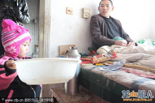 Three-year-old Dong Xinyi helps prepare water for her paralyzed father in Huangjia town of East Chin ...